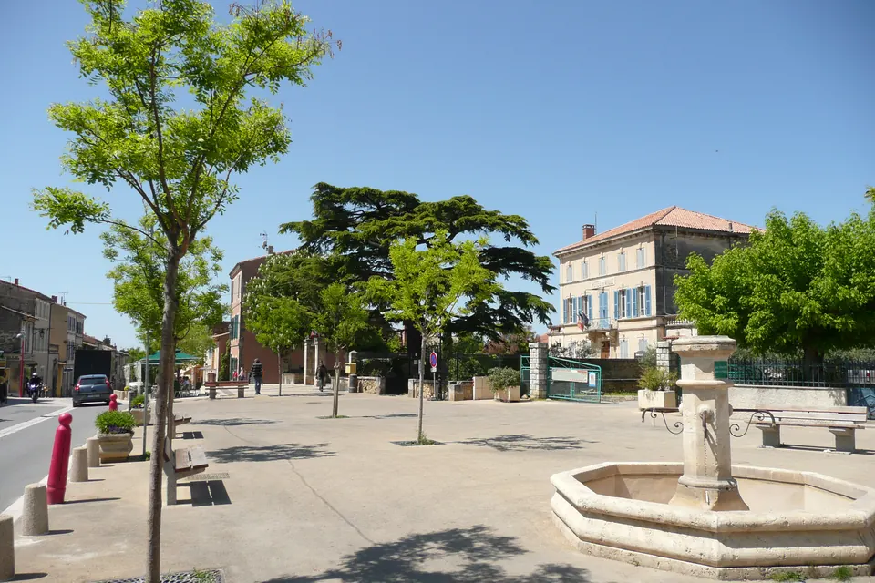 Platz vor dem Rathaus von Lauris mit Brunnen und Bäumen