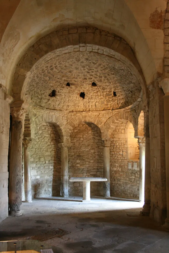Abside voûtée et colonnes en pierre à l’intérieur du baptistère de Venasque.