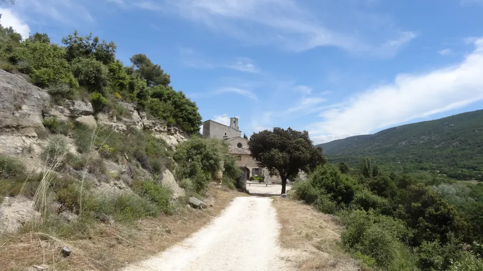Abbaye Saint-Hilaire à Ménerbes, sa façade au bout du chemin et le paysage du Luberon.