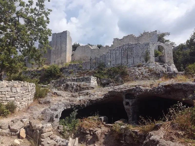 Vestiges du château du fort de Buoux, murs et abris creusés dans la roche.