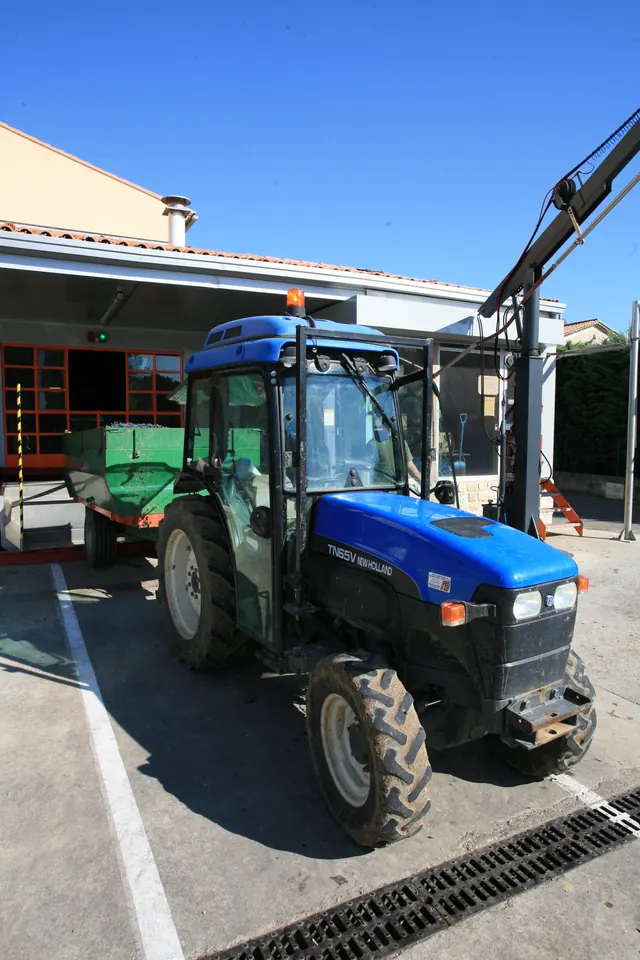 Tracteur devant l'installation de réception des vendanges de la cave de Vacqueyras.