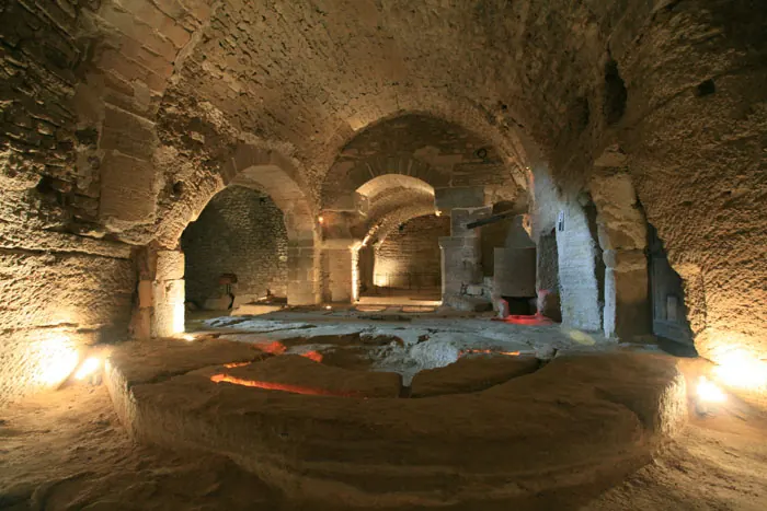 Voûtes de pierre et ancien équipement circulaire dans les caves du Palais Saint-Firmin