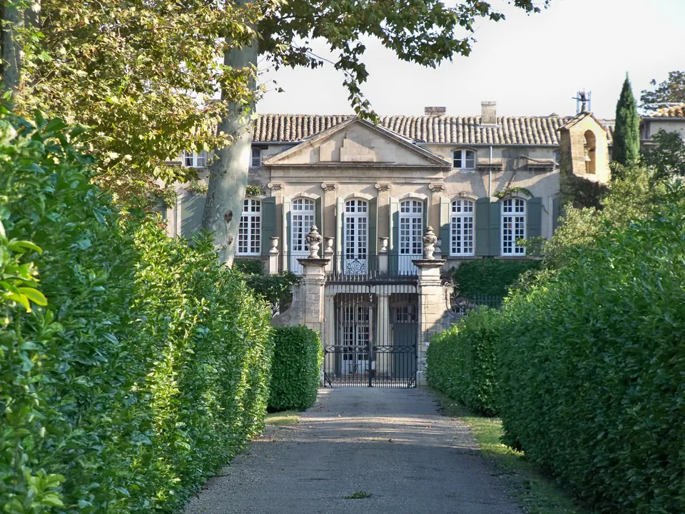 Allée bordée de végétation conduisant à la façade du château de Brantes à Sorgues
