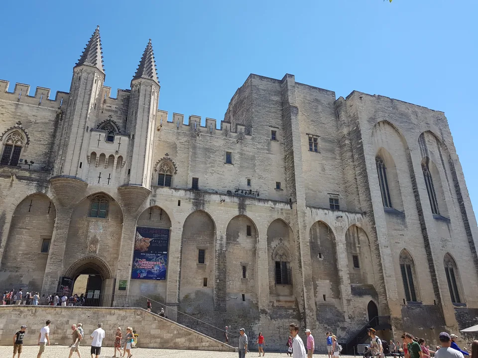 Façade du Palais des Papes depuis la place, photographie d’août 2017, avant la transformation actuelle du parcours.