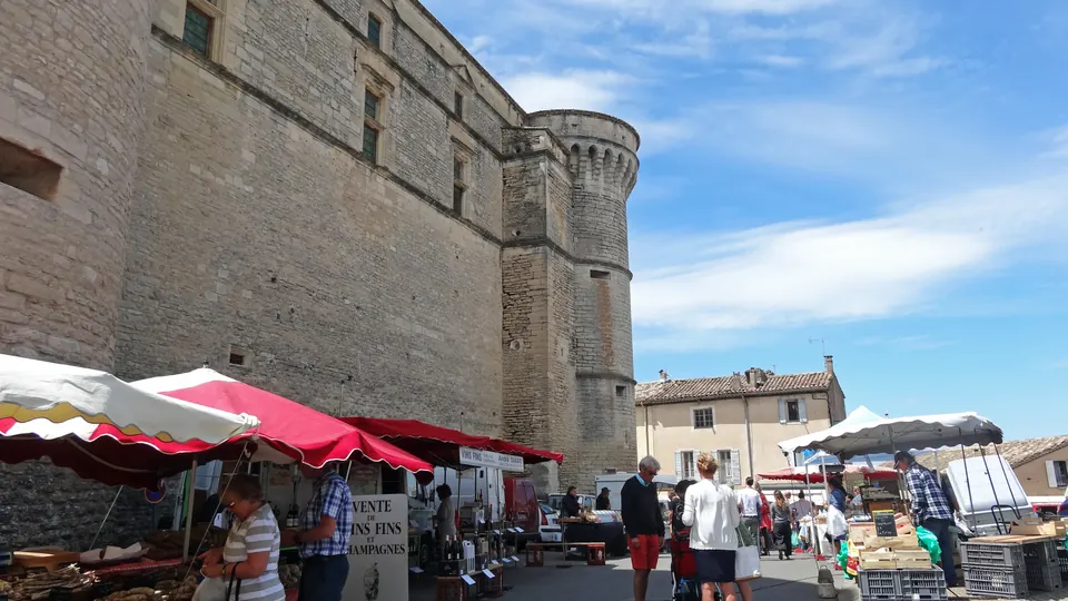Le château de Gordes et sa tour au-dessus des étals du marché.